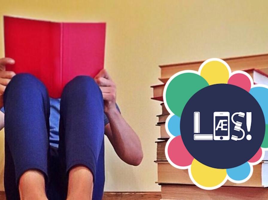 Billede af læsende barn forfra. Ansigtet helt skjult af en bog, som barnet er fordybet i.